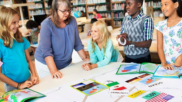 Teacher and students interacting in a classroom.