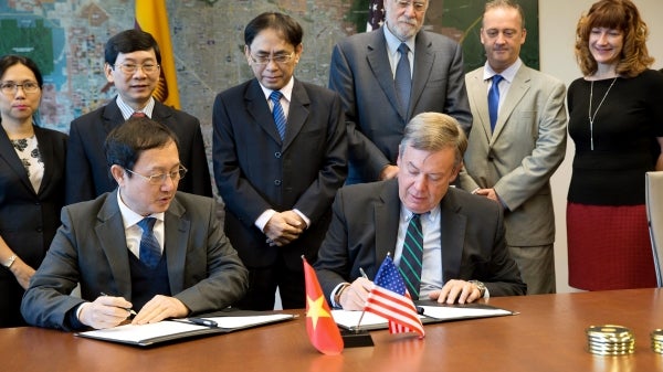 people signing papers at desk