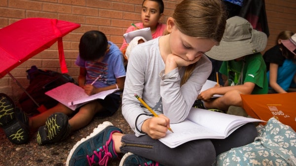 young children sitting and writing