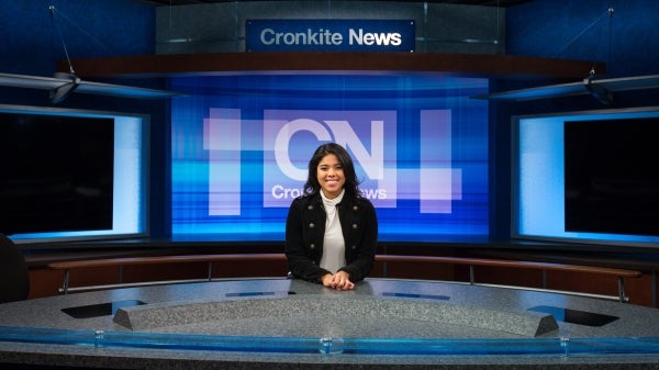 journalsim student sitting at newsdesk