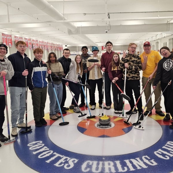 A group of students pose with sports equipment