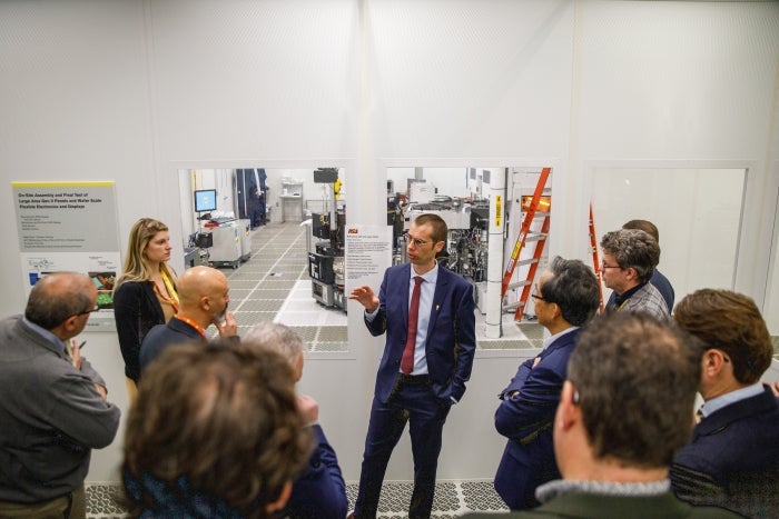 Man speaking to group of people in semiconductor lab facility