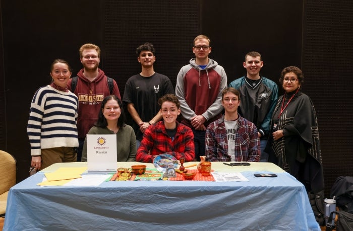 Group of people pose behind table display