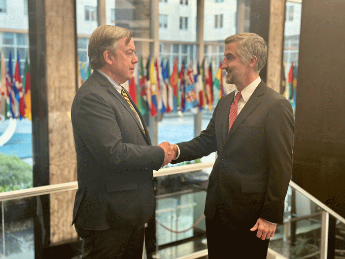 Two men in suits shake hands