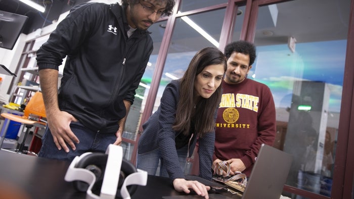 Hasti Seifi works with students at a laptop