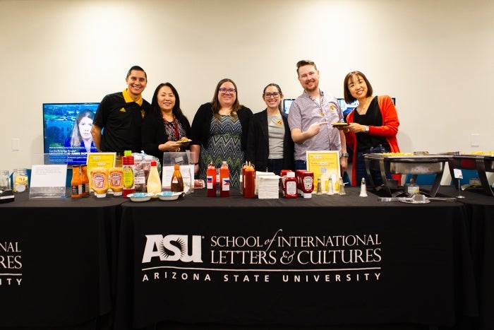 Group of people posing behind table