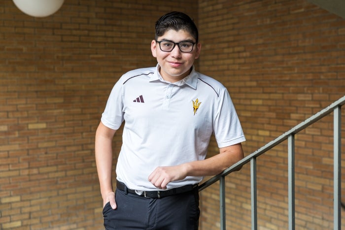 Young man with glasses smiling on a staircase