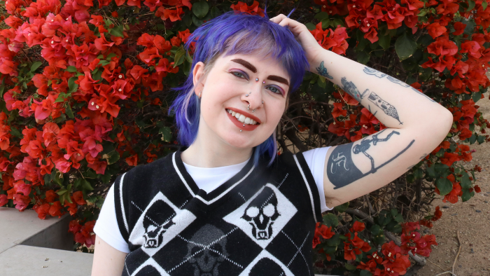 Self-portrait of Bailey Pyritz in foreground, fuchsia bougainvillea blooms in background