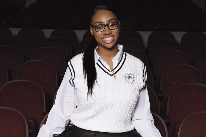 ASU grad Dorothy Jean Tillman II  sits in a theater