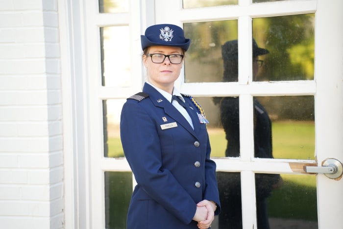 Leah Faiella stands in front of a large white door with windows. 