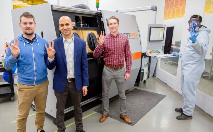 Three professors pose in a lab.