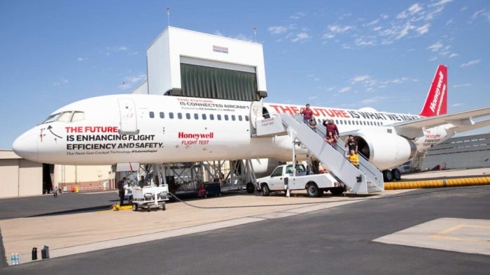 ASU students standing on the stairs of a Honeywell airplane.