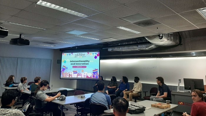 Out in STEM members at a panel event with a projector screen