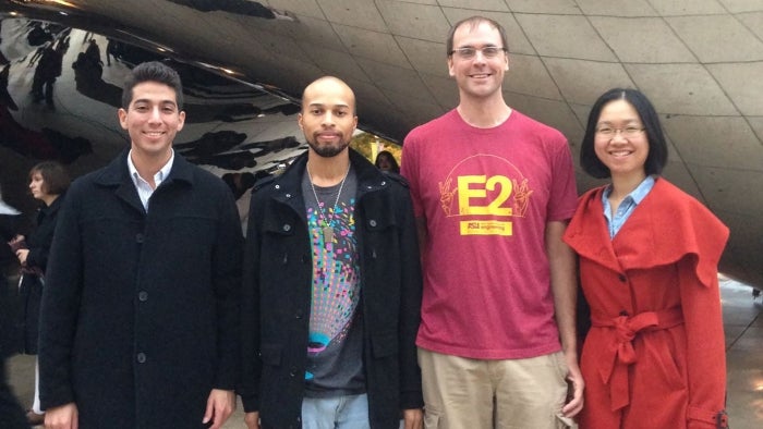 A team of student researchers poses with Ross Maciejewsk in front of the Cloud Gate sculpture in Chicago.