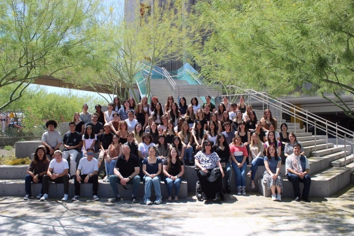 Juniors in ASU's graphic design program pose for a group photo on an outdoor staircase.