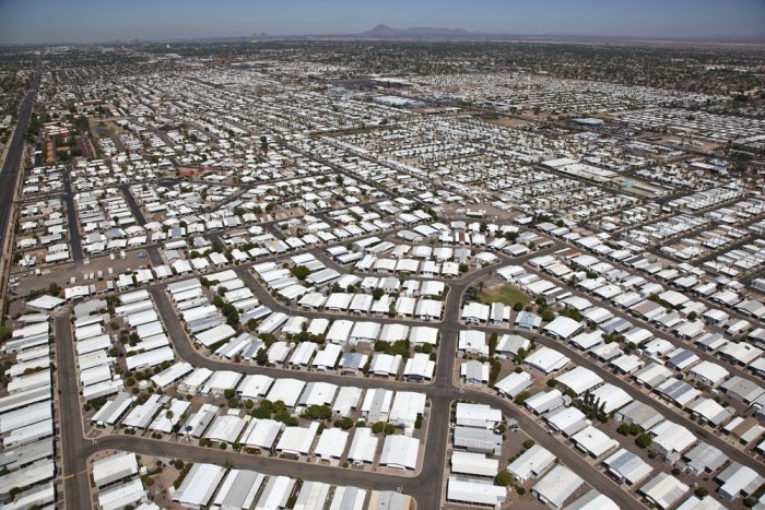 Aerial view of a sprawling mobile home park arranged in a grid pattern with mountains in the distance.