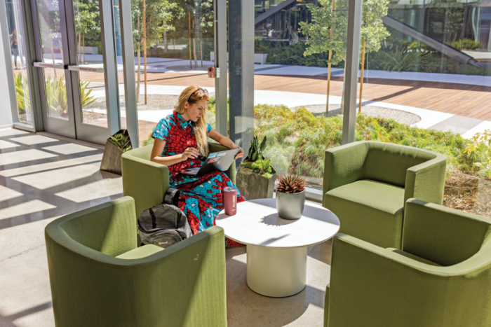 Woman sitting in a green chair in a lobby