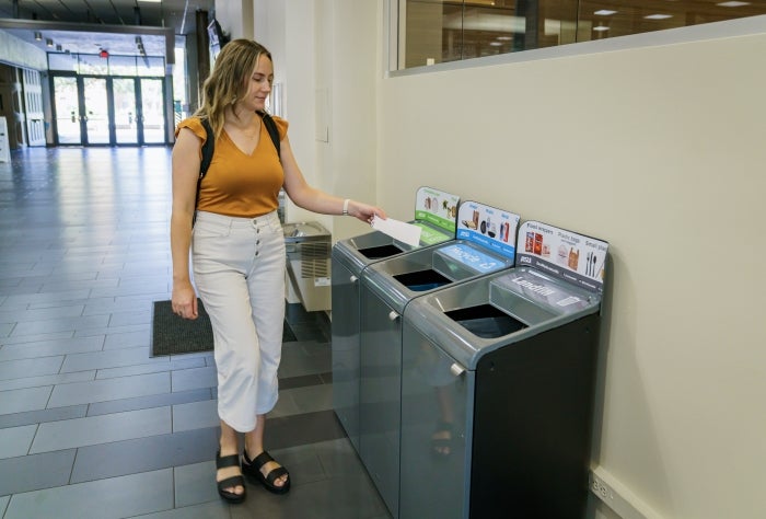 ASU employee puts a piece of paper in a recycling bin in the Memorial Union on the Tempe campus. 