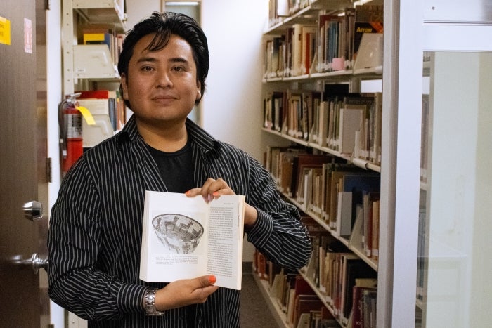 Dance student holds the book written by his great-great-great grandmother