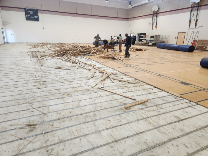 Volunteers removing flooring from Williams Air Force Base elementary school. 