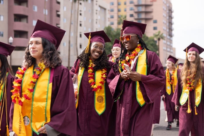 Graduates in regalia walk in a group