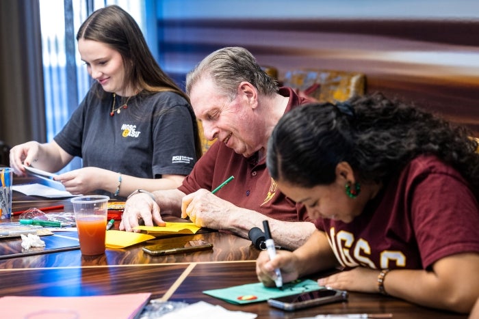 older and younger people sit at a table