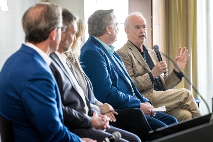 A group of panelist sit in a row