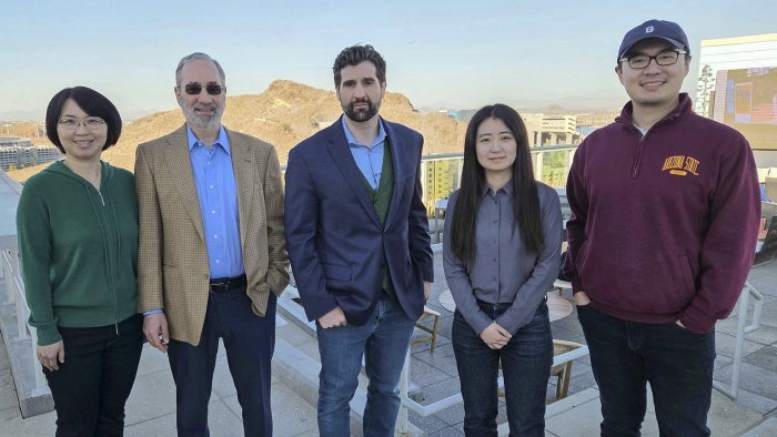 A group of researchers pose with the Tempe cityscape in the background.