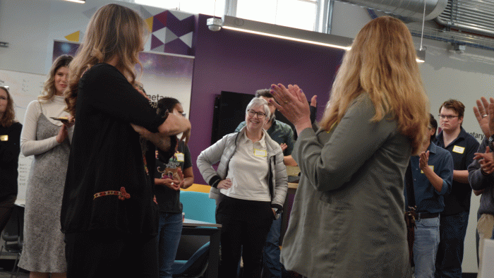 Lindy Elkins-Tanton stands in the middle of a crowd clapping for her