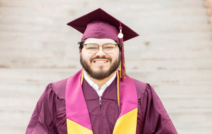 ASU graduate Manuel Lewis in cap and gown