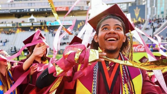 ASU grad Dallas Salas wearing a maroon cap and gown at a graduatino ceremony.