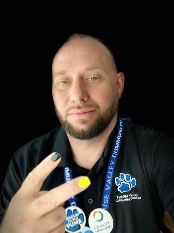 Portrait of man with beard and painted nails making peace sign