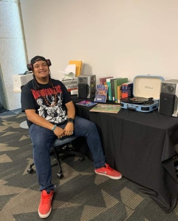 Student sitting next to record player