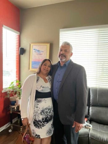 Man and woman posing in a living room.