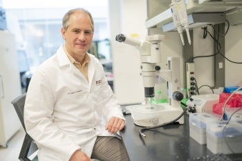 Carlo Maley in a lab wearing a white coat.