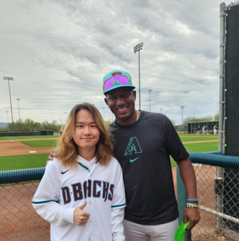 Sungkwon and a professional baseball player at a baseball field, Sungkwon is wearing a Diamondbacks jersey and giving a thumbs-up.