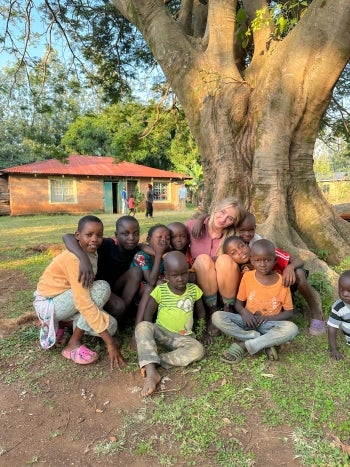 Photo of Tatum McMillan with children in Kenya.