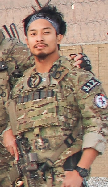 A man in camo uniform poses for a photo.