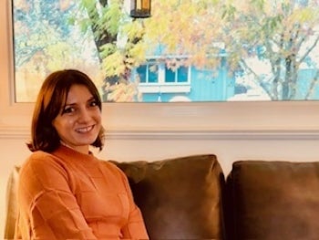 Laura Berzinas sitting in front of a window smiling