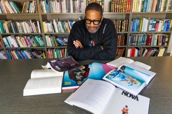 Mitchell Jackson looking through a spread of books on a table