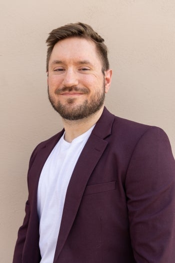 Portrait of ASU graduate in a maroon blazer