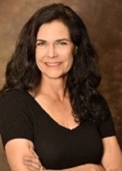 Portrait of woman with long brown hair in brown top