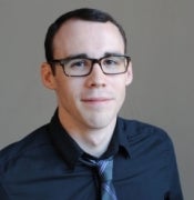 Portrait of man in collared shirt and tie wearing glasses