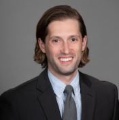 Man with coat and tie smiling