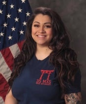 Shannon Zellner posing in front of the American flag on a military base in Japan. 