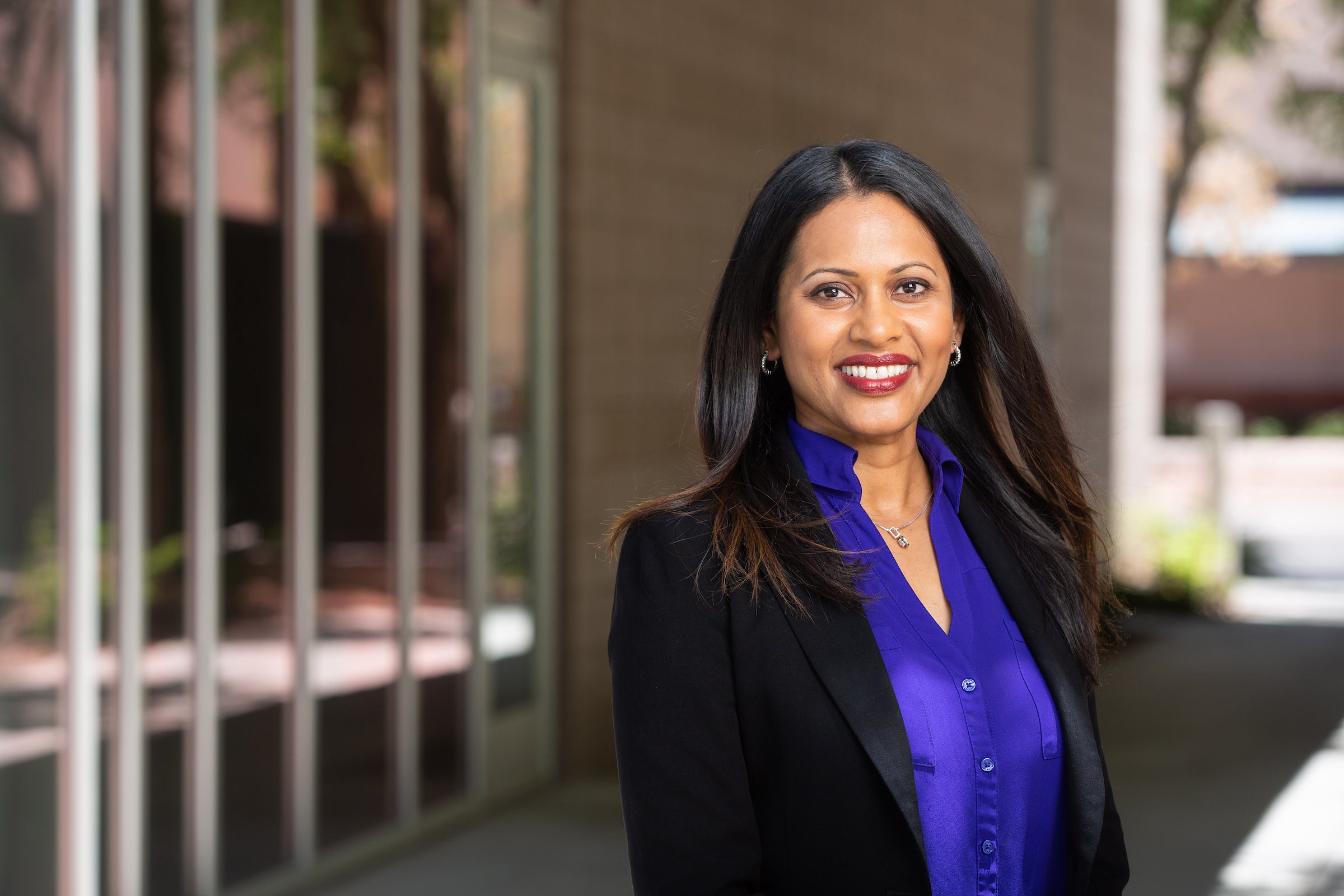 Portrait of woman in purple blouse and black blazer and long black hair