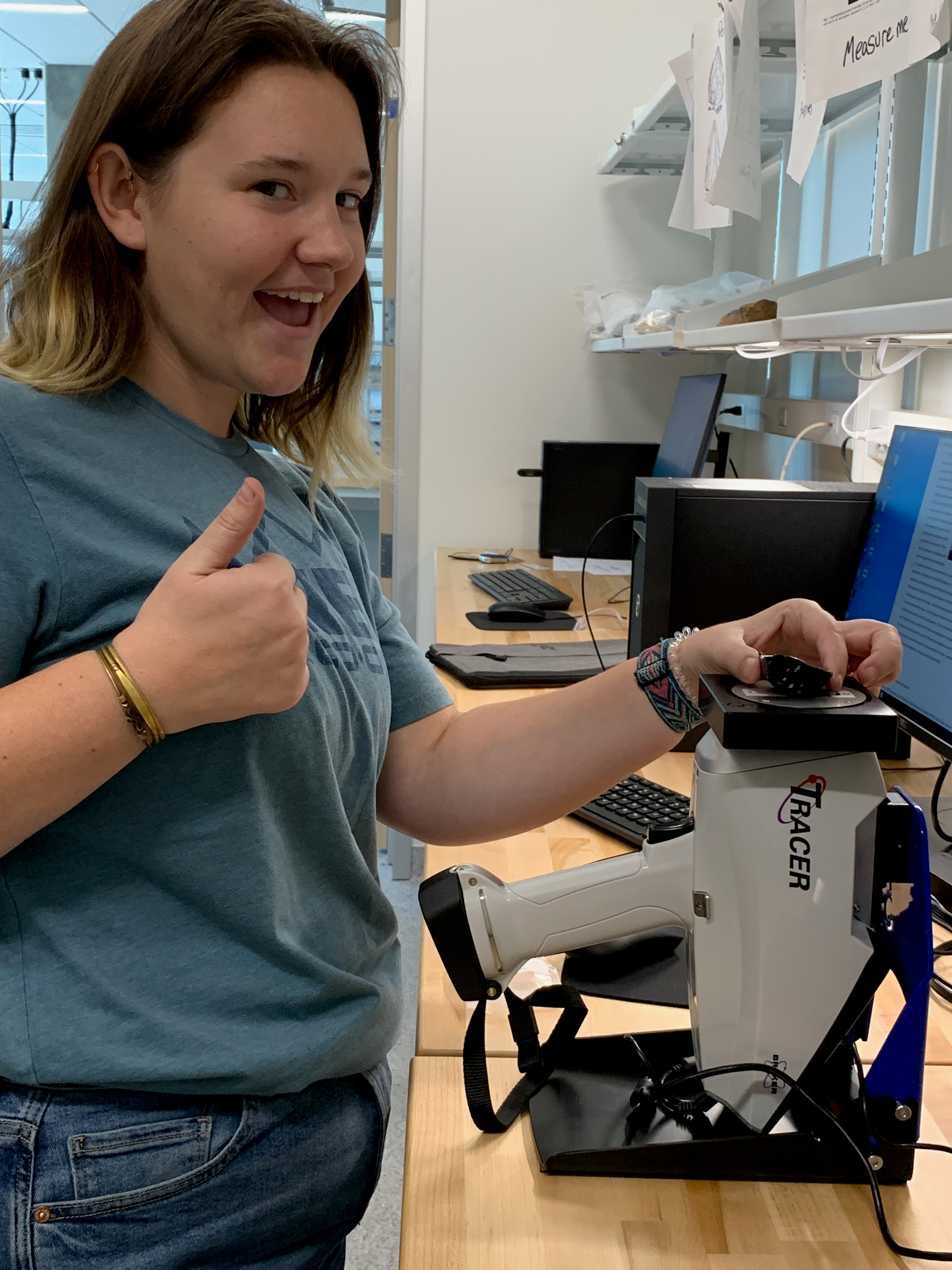 ASU student researcher in a lab giving a thumbs up to the camera