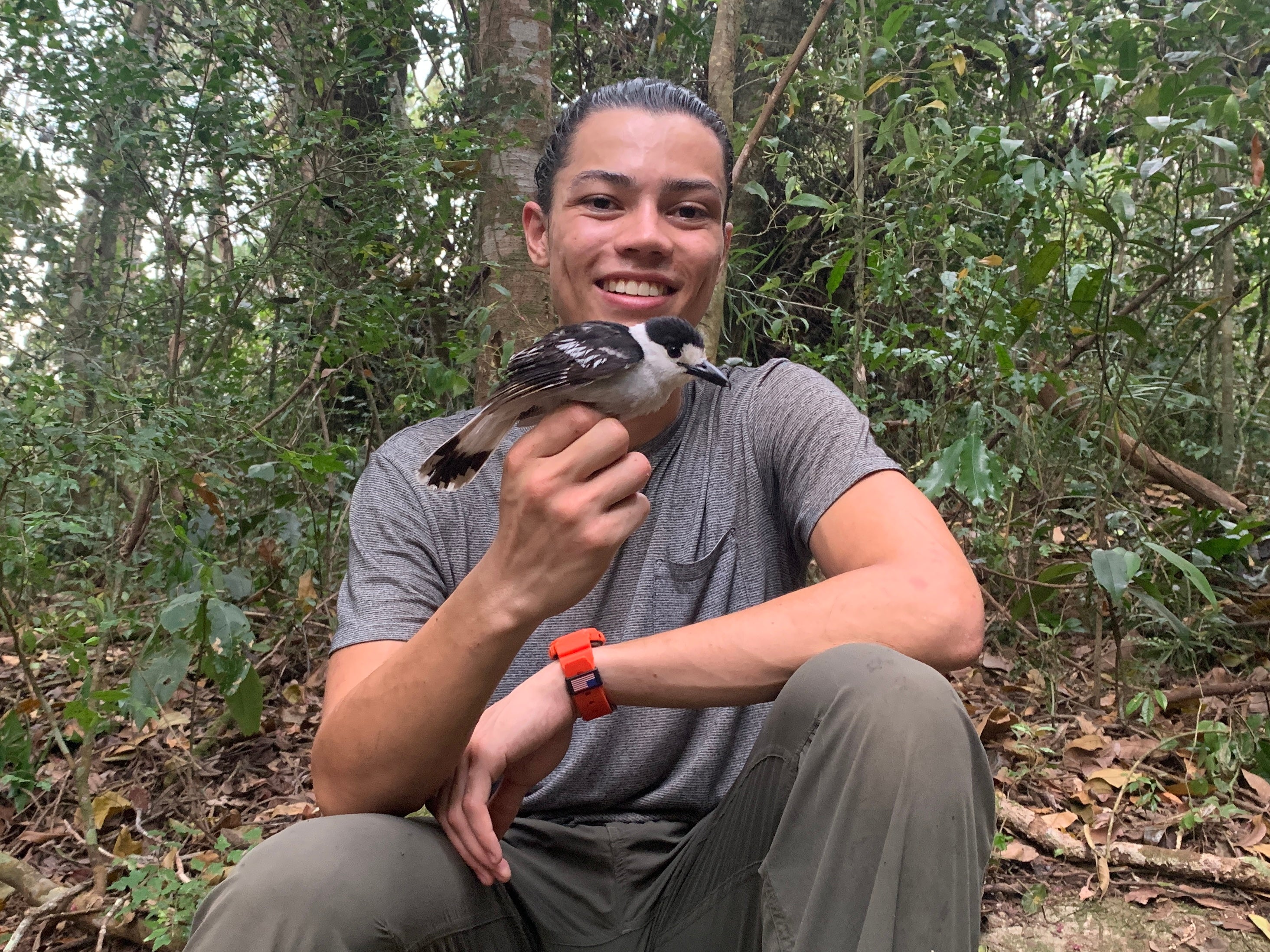 ASU alum Tahiry Langrand holds a bird in a forest