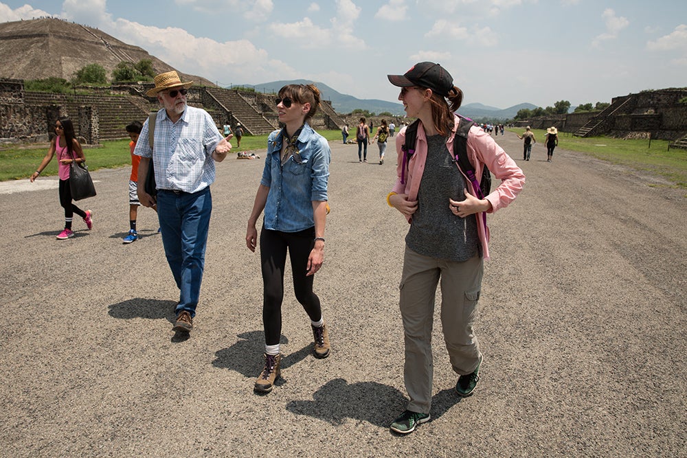 three people walking in ancient city