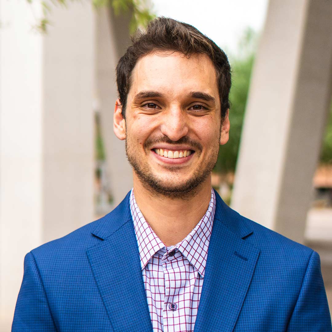 Graduate student  smiles at the camera.